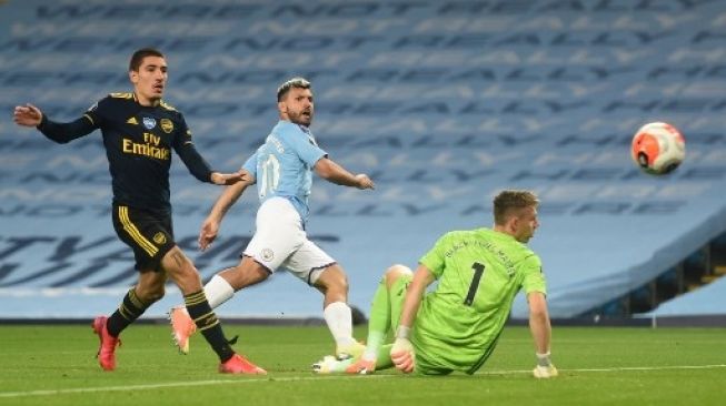 Pemain Manchester City Sergio Aguero menjebol gawang Arsenal dalam pertandingan Liga Inggris di Etihad Stadium, Kamis (18/6/2020). [AFP]