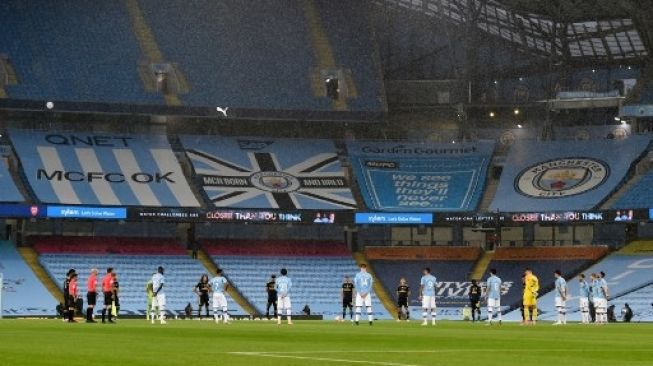 Para pemain Manchester City dan Arsenal mengheningkan cipta sebelum pertandingan Liga Inggris di Etihad Stadium, Kamis (18/6/2020). [AFP]