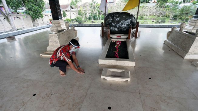 Petugas Dinas Pariwisata memasang tanda menjaga jarak bagi peziarah di pusara Makam Presiden Soekarno di Blitar, Jawa Timur, Jumat (19/6/2020). [ANTARA FOTO/Irfan Anshori]