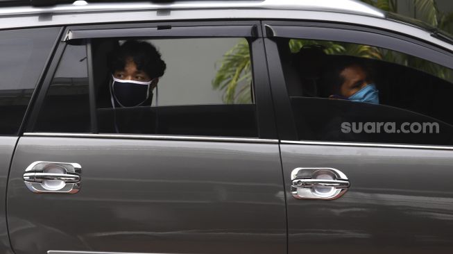 Seorang murid berada di dalam mobil menunggu giliran untuk menerima pengalungan medali dari guru sebagai tanda wisuda kelulusan sekolah secara "Drive Thru" di Madrasah Aliyah Annajah, Ciledug Raya, Jakarta, Jumat (19/6). [Suara.com/Angga Budhiyanto]