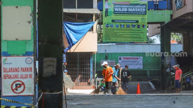 Para pedagang memindahkan barang - barang di Pasar Minggu, Jakarta Selatan, Sabtu (20/6). [Suara.com/Alfian Winanto]