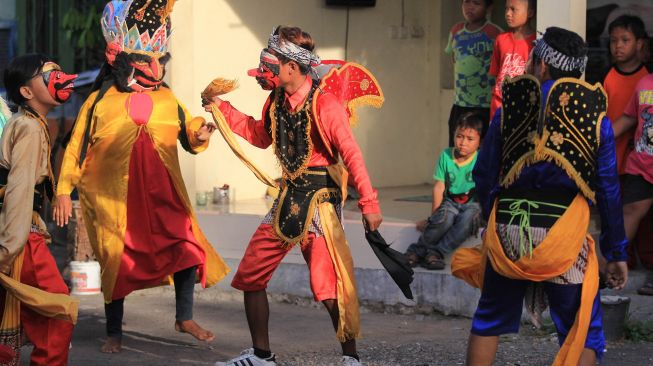 Sejumlah seniman tari dari kelompok Bleknong Pekandangan mengamen di jalan perkampungan Desa Pekandangan, Indramayu, Jawa Barat, Jumat (19/6/2020).  [ANTARA FOTO/Dedhez Anggara]
