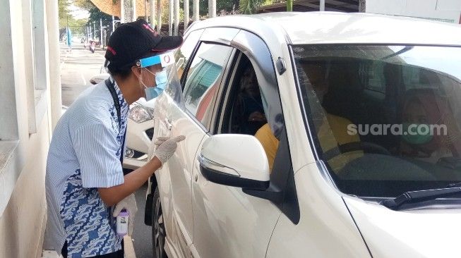 Petugas pintu masuk tampak tengah berbicara dengan pengunjung TMII, Sabtu (20/6/2020). [Suara.com/Adie Prasetyo Nugraha]