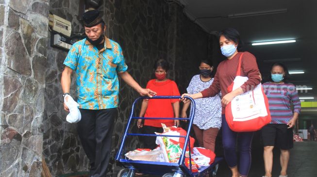 Warga usai mengambil paket sembako di Gedung GP Ansor, Kramat Raya, Jakarta Pusat, Jumat (19/6/2020). [Suara.com/Oke Atmaja]