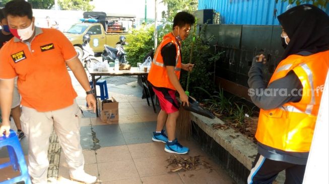 Warga tak pakai masker di CFD Jakarta diminta sapu jalan. (Suara.com/Fakhri Fuadi)