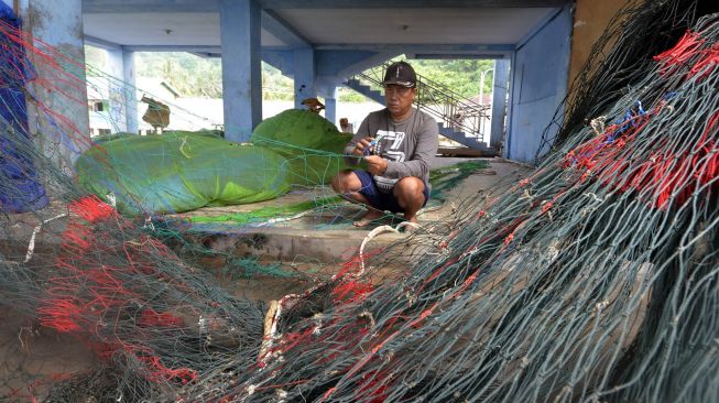 Nelayan memperbaiki jaring di Pelabuhan Pelelangan Ikan Lampasing, Bandar Lampung, Lampung, Senin (22/6/2020). [ANTARA FOTO/Ardiansyah]
