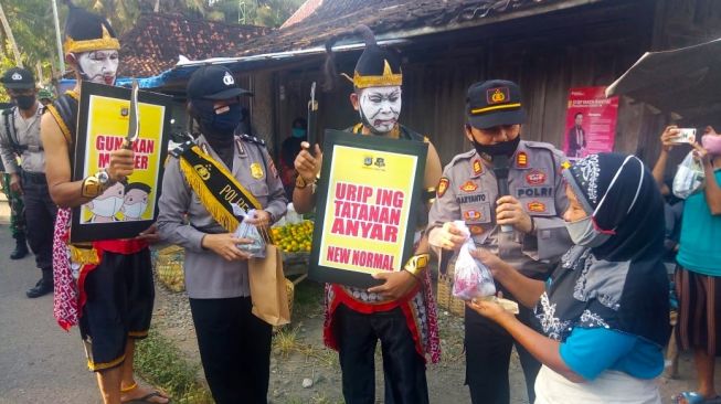 Ketahuan Tak Pakai Masker, Jumini Dihukum Punokawan dari Polsek Panjatan