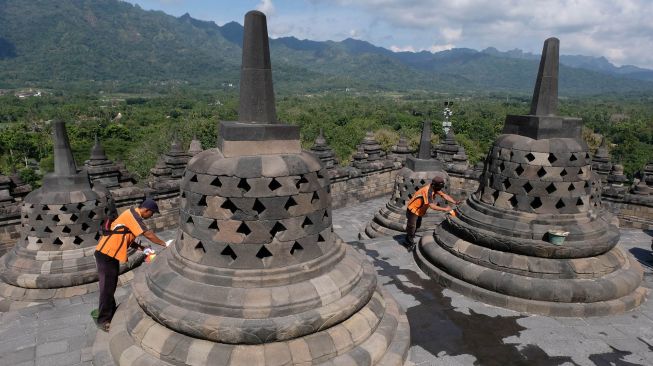 Petugas Balai Konservasi Borobudur (BKB) menyemprotkan air saat membersihkan abu vulkanik erupsi gunung Merapi di Candi Borobudur, Magelang, Jawa Tengah, Senin(22/6/2020).  [ANTARA FOTO/Anis Efizudin]
