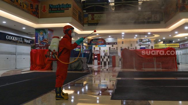 Petugas melakukan penyemprotan disinfektan di Blok M Square, Jakarta Selatan, Selasa (23/6). [Suara.com/Alfian Winanto]