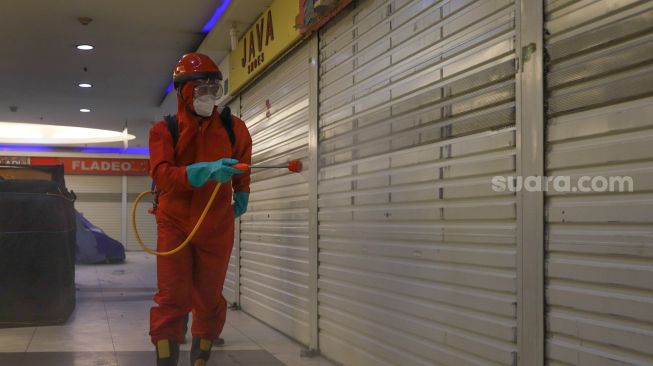 Petugas menyemprot disinfektan di Blok M Square, Jakarta Selatan, Selasa (23/6). [Suara.com/Alfian Winanto]