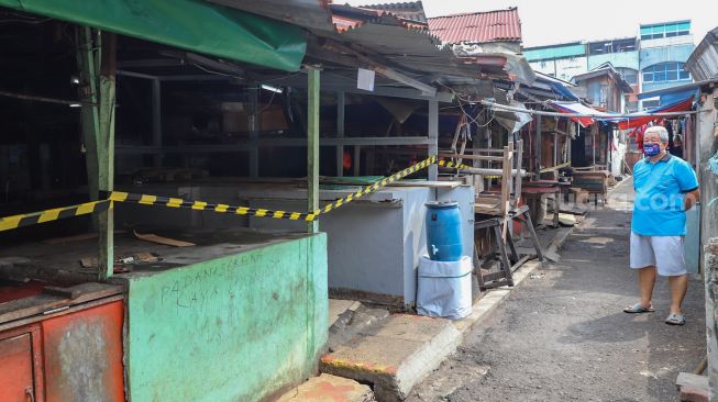 Warga melintas di sekitar area Pasar Cideng Thomas, Jakarta Pusat, Selasa (23/6). [Suara.com/Alfian Winanto]