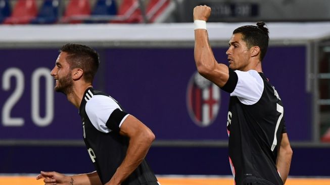 Megabintang Juventus, Cristiano Ronaldo (kanan) merayakan golnya ke gawang Bologna dalam laga lanjutan Liga Italia 2019/2020 di Renato Dall'Ara, Bologna, Selasa (23/6/2020) dini hari WIB. [Miguel MEDINA / AFP]