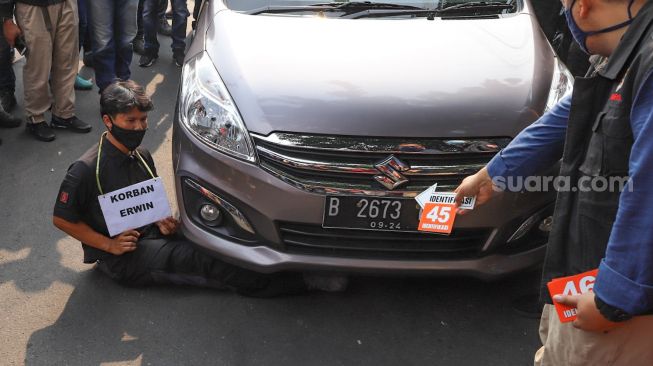 Reka adegan pembunuhan Yustus Corwing Rahakbau alias Erwin saudara dari Nus Kei oleh kelompok John Kei dengan cara dilindas tubuhnya oleh mobil di Duri Kosambi, Jakarta Barat, Rabu (24/6). [Suara.com/Alfian Winanto]
