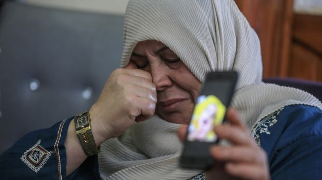 Kerabat bayi Omer Yagi 9 bulan, yang tidak dapat meninggalkan Gaza untuk dirawat karena blokade Israel dan meninggal, menangis saat memperlihatkan foto sang bayi di Kota Gaza, Gaza pada 23 Juni, 2020. [Foto/Anadolu Agency]