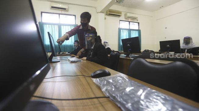 Sejumlah siswa mengikuti pelatihan komputer saat persiapan normal yang baru di Sekolah Menengah Kejuruan (SMK) Jayawisata 2, Jakarta, Rabu (24/6). [Suara.com/Angga Budhiyanto]