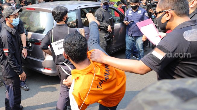 Korban Erwin ditendang setelah mencoba lari dari kelompok John Kei saat rekonstruksi di Duri Kosambi, Jakarta Barat, Rabu (24/6). [Suara.com/Alfian Winanto]