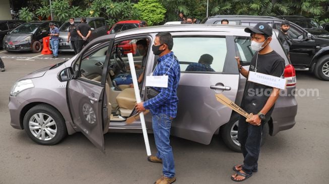 Para tersangka memasuki kendaraan untuk berangkat menyerang kediaman Nus Kei saat rekonstruksi di Polda Metro Jaya, Jakarta Pusat, Rabu (24/6). [Suara.com/Alfian Winanto]