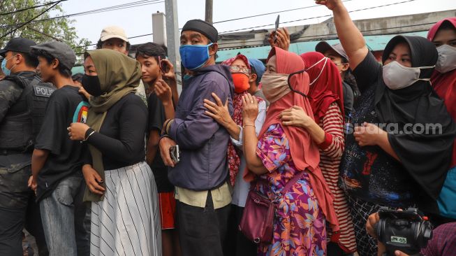 Warga berdesak-desakan saat melihat rekonstruksi kelompok John Kei di Duri Kosambi, Jakarta Barat, Rabu (24/6). [Suara.com/Alfian Winanto]