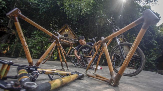 Perajin memproduksi sepeda dari bambu di sentra produksi sepeda bambu Jatnika, Cibinong, Kabupaten Bogor, Jawa Barat, Rabu (24/6/2020).  [ANTARA FOTO/Yulius Satria Wijaya]