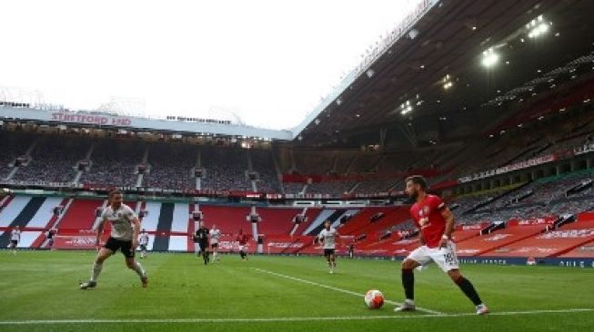 Pemain Manchester United Bruno Fernandes mencoba melewati pemain Sheffield United dalam pertandingan Liga Inggris yang berlangsung di Old Trafford, Kamis (25/6/2020). [AFP]