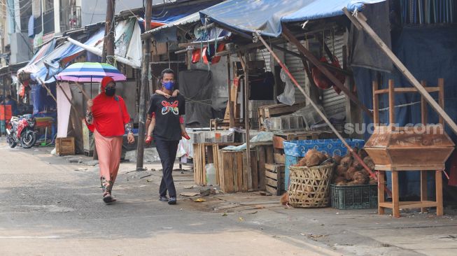 Pedagang tertidur diatas lapak dagangnya di Pasar Enjo, Jakarta Timur, Jumat (26/6). [Suara.com/Alfian Winanto]