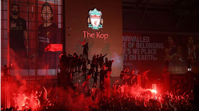 Suporter merayakan keberhasilan Liverpool menjadi juara Liga Inggris 2019/2020 di luar Anfield di Liverpool, Inggris, 25 Juni 2020.  [Oli SCARFF / AFP]