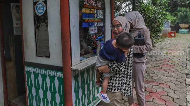 Warga membeli tiket wahana sepeda air di Setu Babakan, Jakarta Selatan, Sabtu (27/6). [Suara.com/Alfian Winanto]
