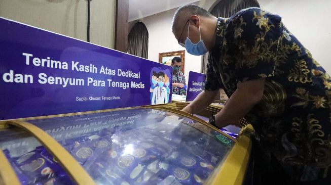 Pekerja saat merapikan tumpukan box eskrim Aice Susu telur yang akan diserahkan kepada rumah sakit rujukan Covid 19 di RS PGI Cikini, Jakarta Pusat, Jumat (26/6/20).  [Suara.com/Oke Atmaja]