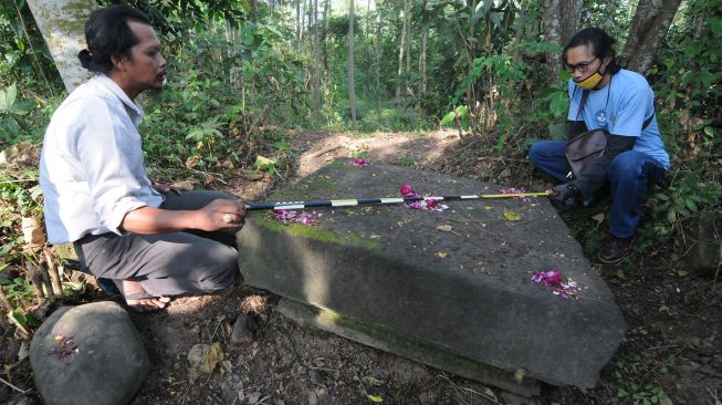 Pegiat cagar budaya dari Klaten Heritage Community (KHC) mengukur dugaan batu yoni candi di sebuah ladang pertanian pohon sengon di Mranggen, Jatinom, Klaten, Jawa Tengah, Jumat (26/6/2020).  [ANTARA FOTO/Aloysius Jarot Nugroho]
