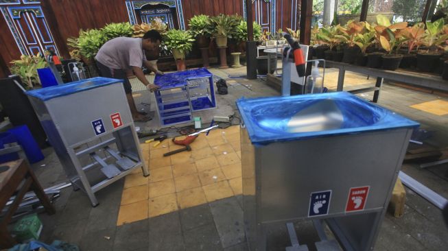 Pengrajin memproduksi wastafel "Anti Corona" di Industri Pandemi Kreatif, Paten, Tridadi, Sleman, D.I Yogyakarta, Minggu (28/6). [ANTARA FOTO/Andreas Fitri Atmoko]