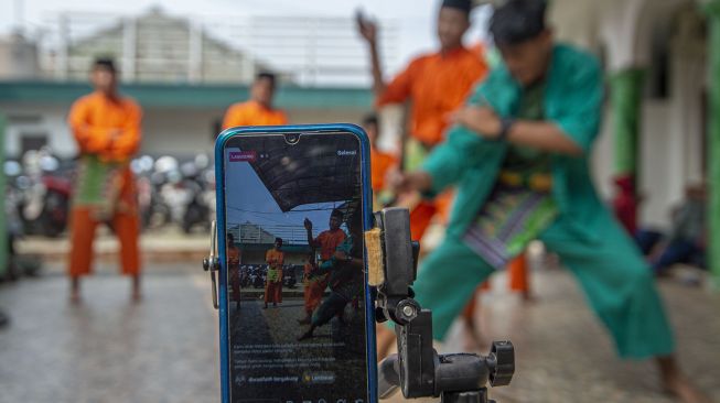 Sejumlah pesilat dari Sanggar Kembang Kelapa menampilkan silat Betawi dalam pentas Manjak Virtual di Cipedak, Jagakarsa, Jakarta, Minggu (28/6). [ANTARA FOTO/Aditya Pradana Putra]