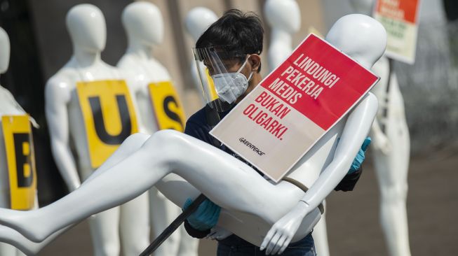 Aktivis Greenpeace memindahkan manekin saat aksi damai menolak pembahasan RUU Cipta Kerja di depan Kompleks Parlemen, Senayan, Jakarta, Senin (29/6). [ANTARA FOTO/Aditya Pradana Putra]