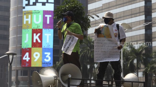 Orang tua murid yang tergabung dalam Forum Relawan PPDB DKI 2020 berorasi di atas mobil komando saat menggelar aksi demonstrasi di depan Kantor Kementerian Pendidikan dan Kebudayaan, Jakarta, Senin (29/6). [Suara.com/Angga Budhiyanto]