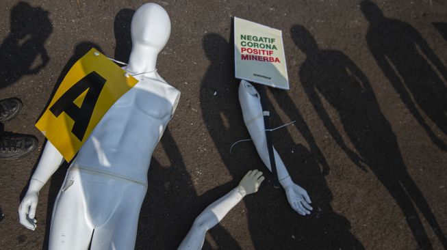 Manekin yang dipasangi poster jatuh tertiup angin saat aksi damai aktivis Greenpeace menolak pembahasan RUU Cipta Kerja di depan Kompleks Parlemen, Senayan, Jakarta, Senin (29/6).  [ANTARA FOTO/Aditya Pradana Putra]