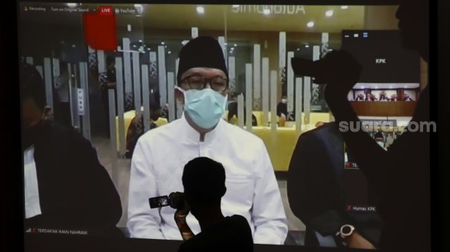 Jurnalis mengambil gambar dari layar yang menyiarkan secara "live streaming" sidang vonis terdakwa mantan Menteri Pemuda dan Olahraga Imam Nahrawi di Gedung KPK, Jakarta, Senin (29/6). [Suara.com/Angga Budhiyanto]