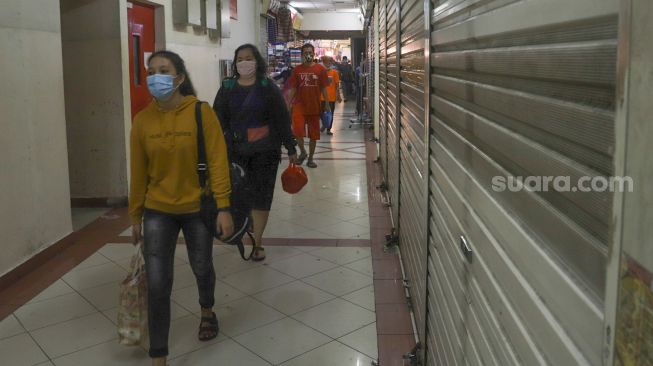 Pengunjung usai berbelanja di Blok B Pasar Tanah Abang, Jakarta Pusat, Selasa (30/6). [Suara.com/Alfian Winanto]