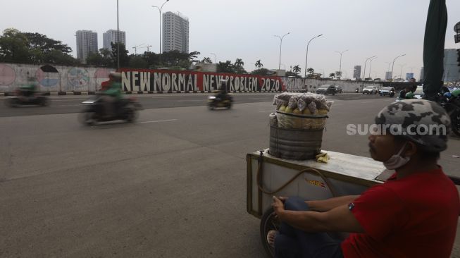 Sejumlah kendaraan melintas di dekat mural bertema tatanan normal baru di Jalan TB Simatupang, Jakarta, Jumat (26/6). [Suara.com/Angga Budhiyanto] 