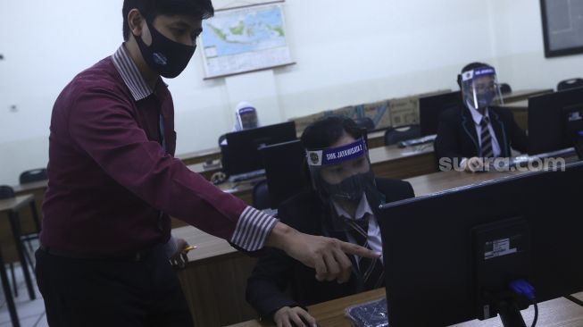 Sejumlah siswa mengikuti simulasi pelatihan komputer saat persiapan normal yang baru di Sekolah Menengah Kejuruan (SMK) Jayawisata 2, Jakarta, Rabu (24/6). [Suara.com/Angga Budhiyanto]