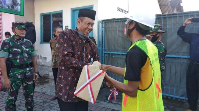 Wali Kota Yogyakarta Haryadi Suyuti membuka kegiatan TMMD Sengkuyung Tahap II TA 2020 Kodim 0734/Yogyakarta dengan menyerahkan alat berupa sekop kepada warga di Kampung Serengan, Kelurahan Ngampilan, Kecamatan Notoprajan, Kota Yogyakarta, Selasa (30/6/2020). - (SuaraJogja.id/Muhammad Ilham Baktora)