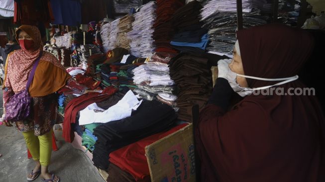 Aktivitas jual beli seragam sekolah di Pasar Jatinegara, Jakarta, Selasa (30/6). [Suara.com/Angga Budhiyanto]