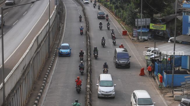 Pengendara motor berputar balik dan melawan arah di depan Gerbang Tol Ciledug, Jakarta Selatan, Rabu (1/7).  [Suara.com/Alfian Winanto]