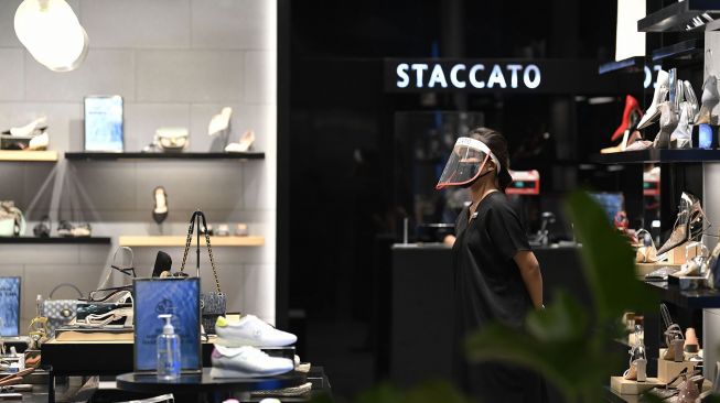 Pramuniaga menerapkan protokol kesehatan dengan mengenakan masker dan faceshield di salah satu tenant Mall Grand Indonesia, Jakarta, Rabu (1/7/2020).  [ANTARA FOTO/Puspa Perwitasari]