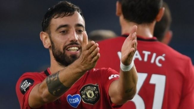 Gelandang Manchester United merayakan gol Bruno Fernandes saat menghadapi Brighton and Hove Albion dalam lanjutan Liga Inggris di American Express Community Stadium. Mike Hewitt / POOL / AFP