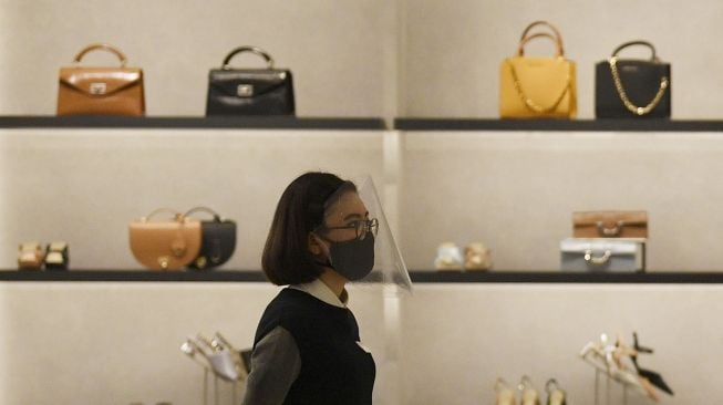 Pramuniaga menerapkan protokol kesehatan dengan mengenakan masker dan faceshield di salah satu tenant Mall Grand Indonesia, Jakarta, Rabu (1/7/2020).  [ANTARA FOTO/Puspa Perwitasari]