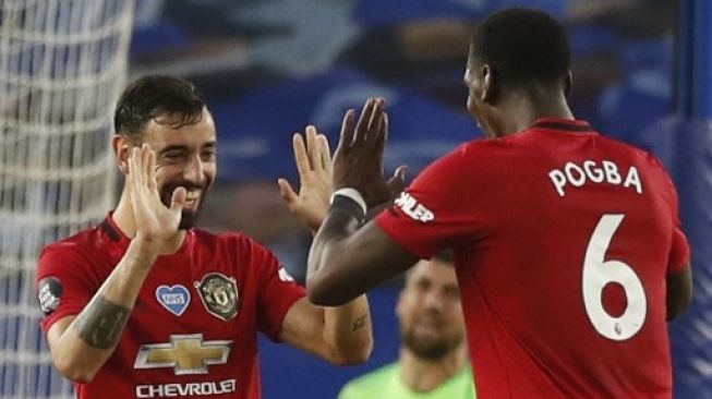 Gelandang Manchester United Bruno Fernandes (kiri) merayakan golnya ke gawang Brighton and Hove Albion dengan Paul Pogba saat laga lanjutan Liga Inggris di American Express Community Stadium. Alastair Grant / POOL / AFP