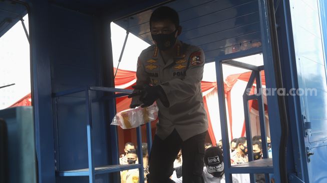 Kapolri Jenderal Polisi Drs. Idham Azis bersiap memusnahkan barang bukti narkoba saat pemusnahan barang bukti hasil penangkapan jaringan narkoba internasional Iran –Timur Tengah di Lapangan Promoter Ditlantas Polda Metro Jaya, Jakarta, Kamis (2/7). [Suara.com/Angga Budhiyanto]