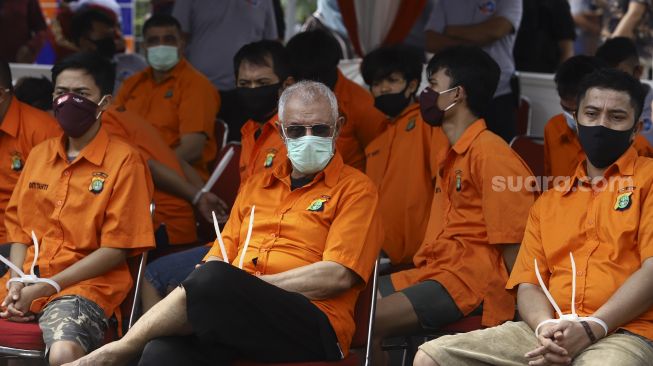 Sejumlah tersangka dihadirkan saat pemusnahan barang bukti hasil penangkapan jaringan narkoba internasional Iran –Timur Tengah di Lapangan Promoter Ditlantas Polda Metro Jaya, Jakarta, Kamis (2/7). [Suara.com/Angga Budhiyanto]