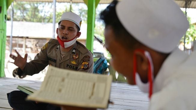 Personel Polda Aceh mengajar para santri mengaji dan bahasa Arab di Dayah Al Hislah Al Aziziyah, Desa Lueng Bata Batoh, Kecamatan Loeng Bata, kabupaten Aceh Besar, Aceh, Rabu (1/7/2020). [ANTARA FOTO/Ampelsa]