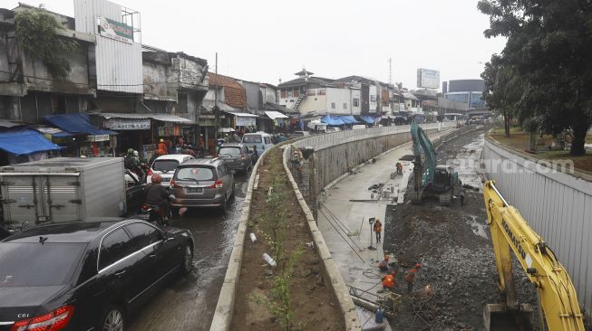 Kendaraan melintas di samping proyek lintas bawah (Underpass) Senen, Jakarta, Kamis (2/7). [Suara.com/Angga Budhiyanto]