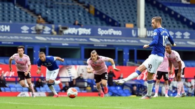 Gelandang Everton Gylfi Sigurdsson mencetak gol ke gawang Leicester City dari titik penalti saat lanjutan Liga Inggris di Goodison Park. PETER POWELL / POOL / AFP